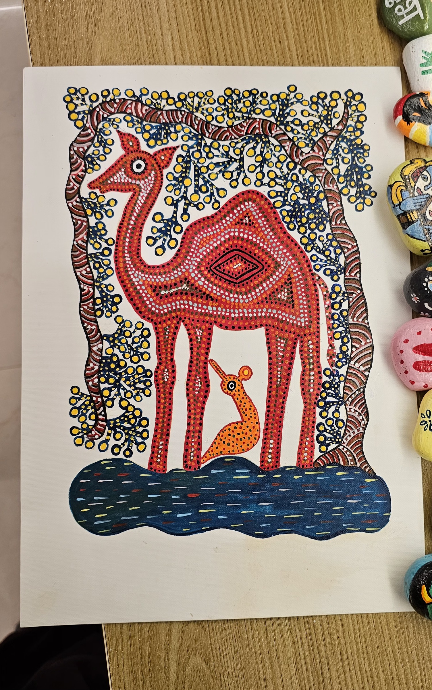 Red dot-patterned camel and calf under a tree, in Gond style.