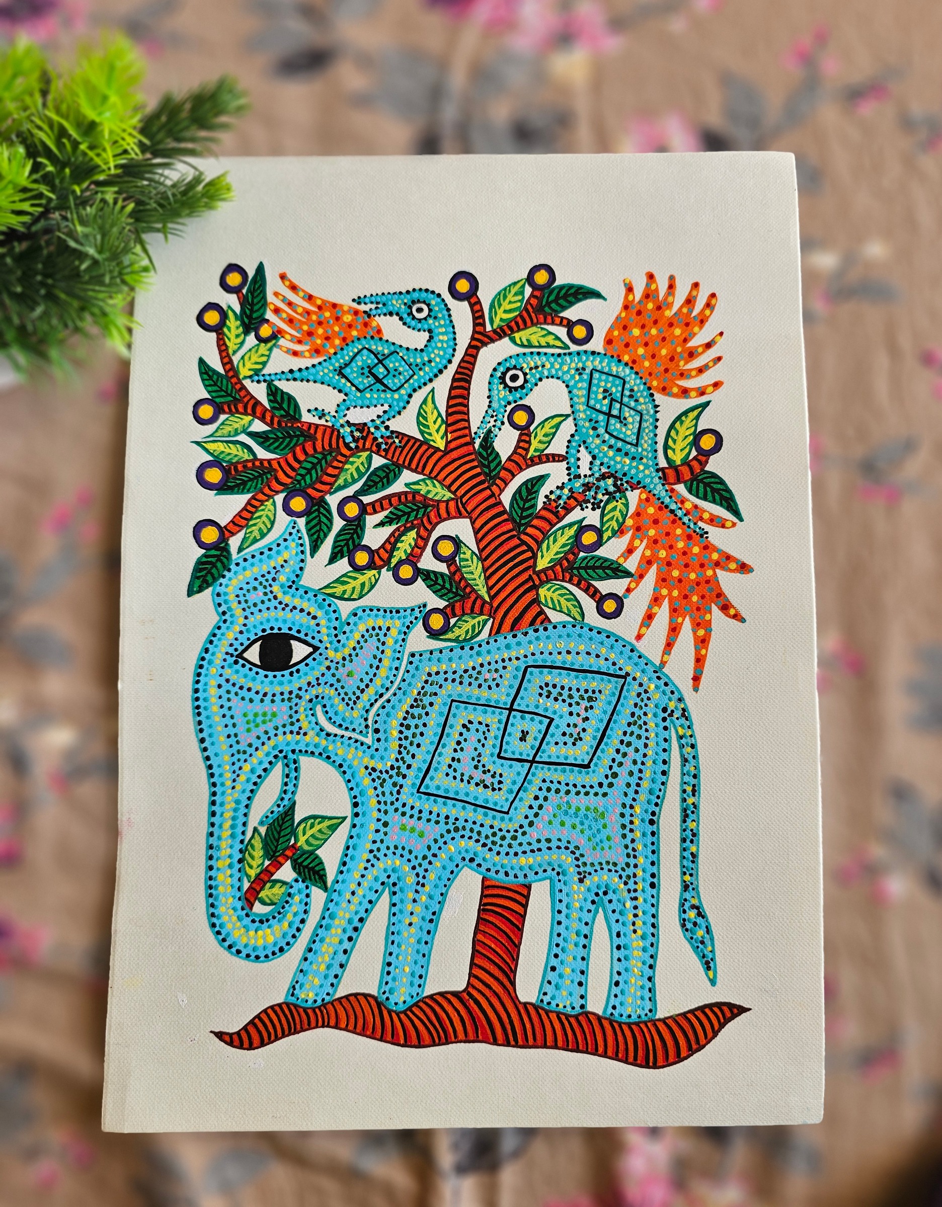 Dot-patterned elephant beneath a tree with two birds.