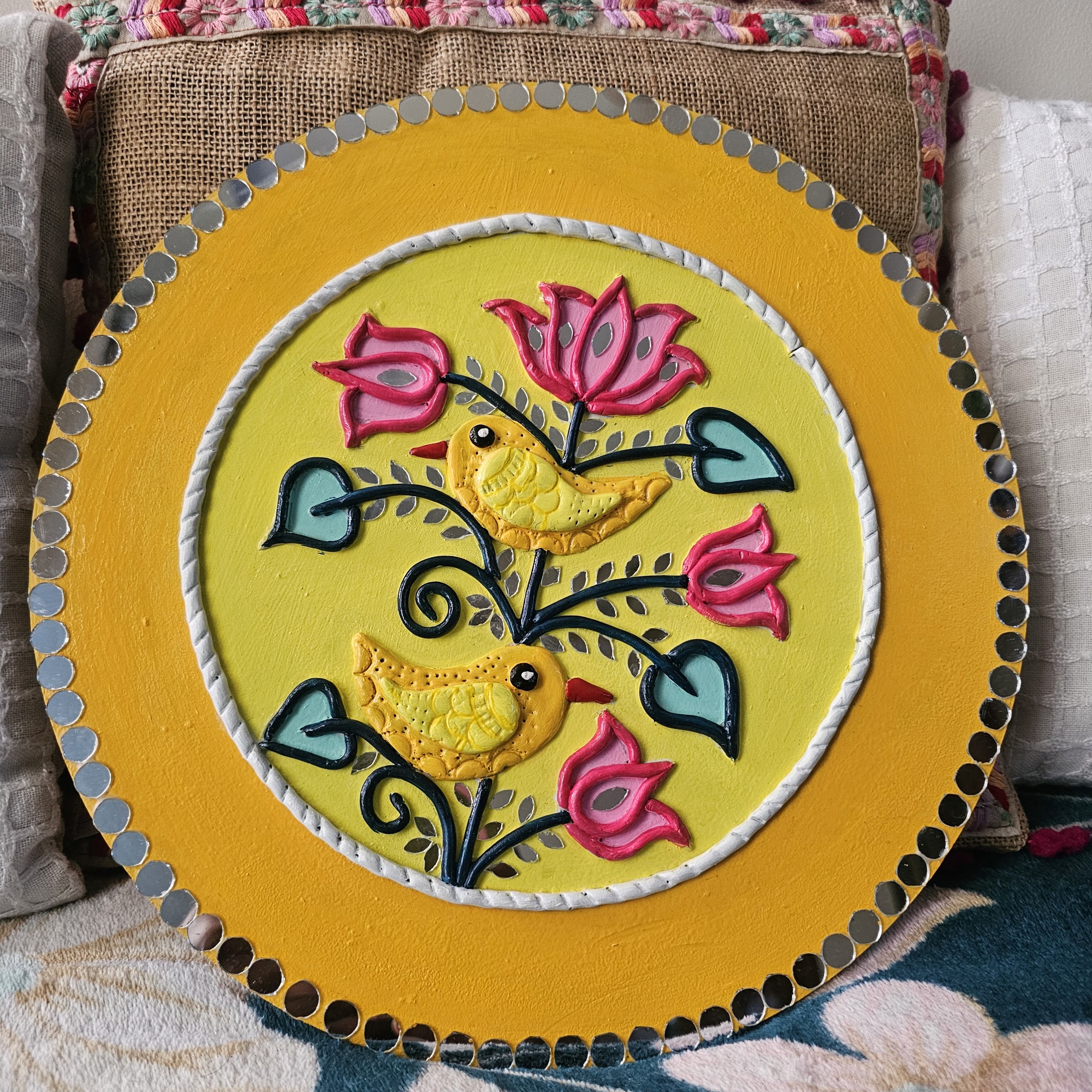 Two birds among lotus blooms in a yellow Lippan mirror panel.