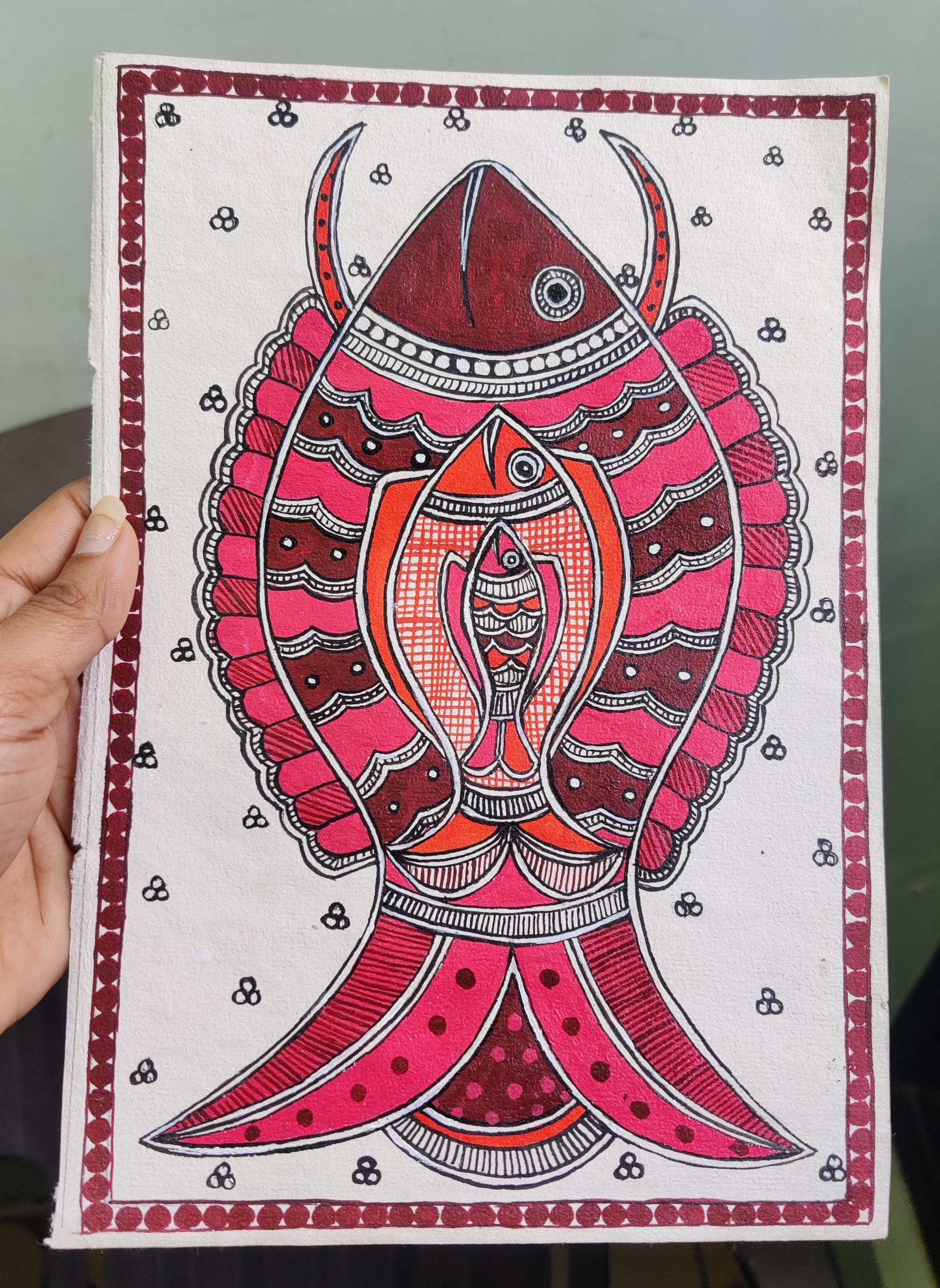 Two layered crimson fish bordered by floral motifs.